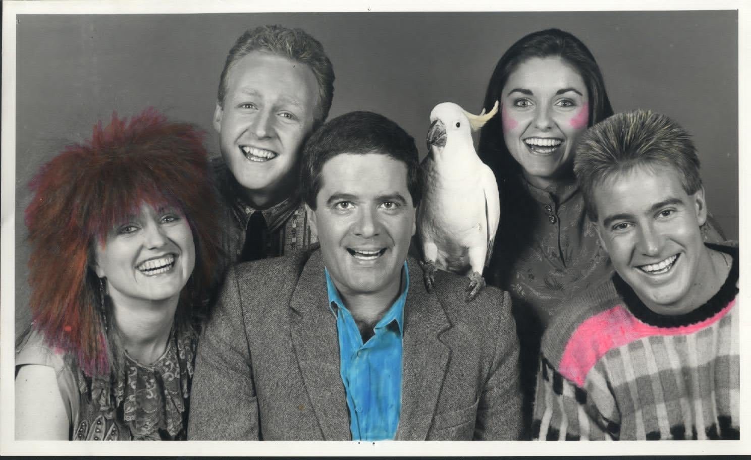 Simon Townsend with the show's cockatoo on his shoulder, surrounded by four young Wonder World reporters